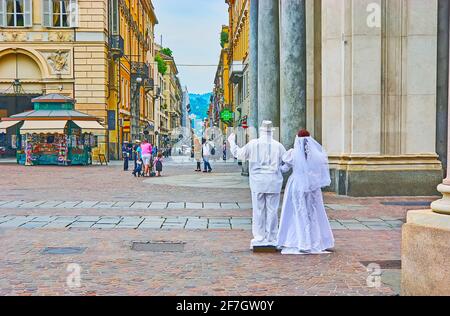 The living sculpture - bride and groom mime artists in white wedding costumes in Piazza San Carlo square, Turin, Italy Stock Photo