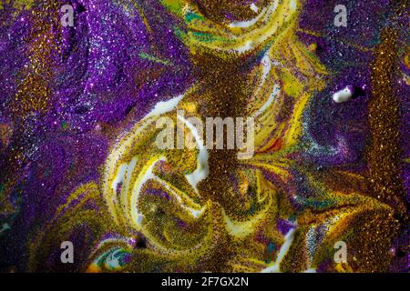 Multicolored acrylic background with curls sprinkled with purple and gold sparkles. Contemporary creativity. A colorful avant-garde painting with rich Stock Photo
