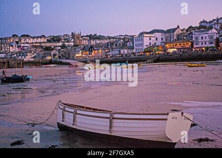 Low tide at St Ives Harbour as the early morning sunlight casts a warm glow over the waterfront Stock Photo