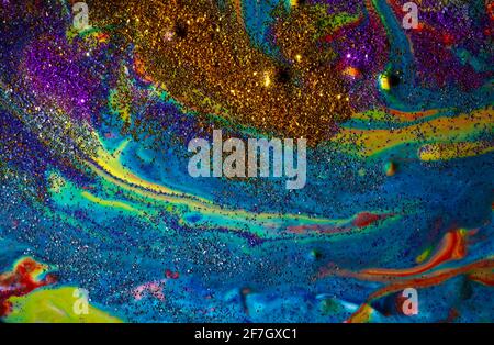 Multicolored acrylic background with curls sprinkled with purple and gold sparkles. Contemporary creativity. A colorful avant-garde painting with rich Stock Photo