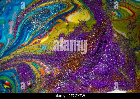 Multicolored acrylic background with curls sprinkled with purple and gold sparkles. Contemporary creativity. A colorful avant-garde painting with rich Stock Photo