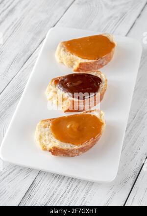 Sandwiches with different types of caramel on the serving plate Stock Photo