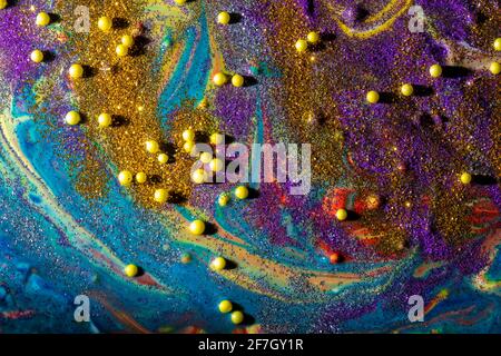 Multicolored acrylic background with curls sprinkled with purple and gold sparkles. Contemporary creativity. A colorful avant-garde painting with rich Stock Photo
