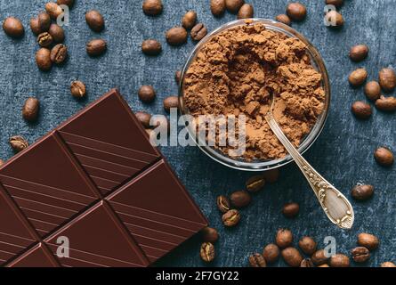 Cocoa powder, fresh fried coffee beans and chocolate bar, close up Stock Photo