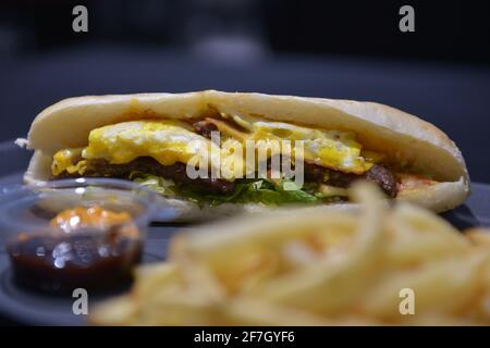 Ground meat sandwich with eggs. And french fries Stock Photo