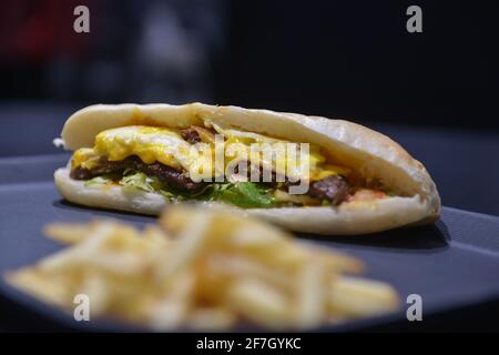 Ground meat sandwich with eggs. And french fries Stock Photo