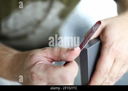 Hands file the edges of the cabinet door Stock Photo