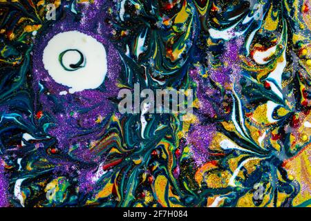 Multicolored acrylic background with curls sprinkled with purple and gold sparkles. Contemporary creativity. A colorful avant-garde painting with rich Stock Photo