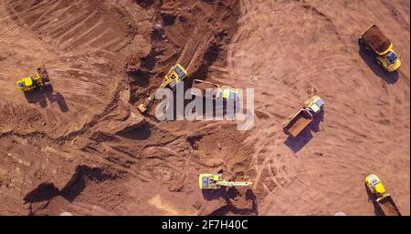 Several Earth moving equipment at new development site. Earth moving machines. Drone view on a New construction site.  Stock Photo