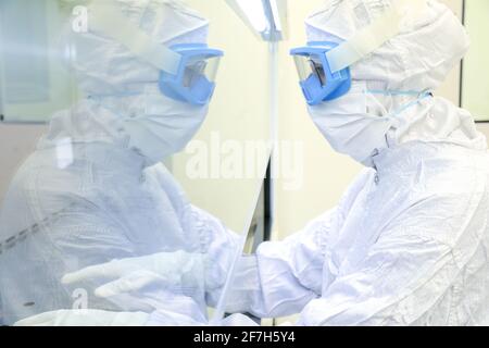 Lab scientists wear protective clothing doing medical research in a science laboratory. Stock Photo
