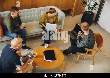 Top view of business team discussing in office. Group of business people having a brainstorming meeting. Stock Photo