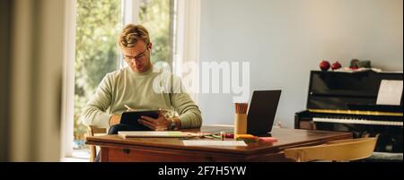 Male designer using graphic tablet and stylus pen. Artist illustrator drawing on tablet at home. Stock Photo