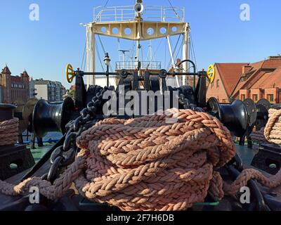 Gdansk, Poland - May 07, 2020: Large thick Rope Used to Moor a Ship. Round wound around a mooring bollards to hold a ship piled together on ship, symb Stock Photo