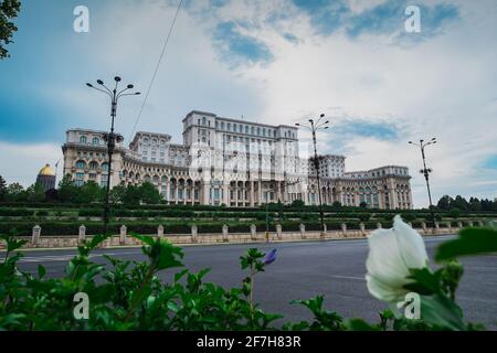 Seat of Romanian parliament, huge building in the centre of Bucharest, Romania on a cloudy summer day. View through the bushes. Epic view of Palatui P Stock Photo