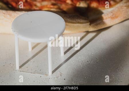 White plastic pizza saver with four legs. A plastic table to save the pizza being squished in the cardboard pizza box. Known also as pizza table, pizz Stock Photo