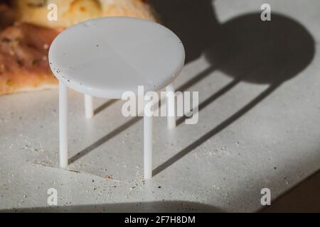 White plastic pizza saver with four legs. A plastic table to save the pizza being squished in the cardboard pizza box. Known also as pizza table, pizz Stock Photo