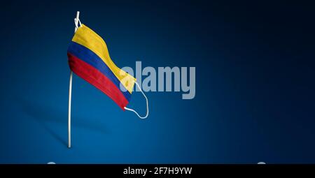 Colombia mask on dark blue background. Waving flag of Colombia painted on medical mask on pole. Virus Attack flag. Concept of The banner of the fight Stock Photo