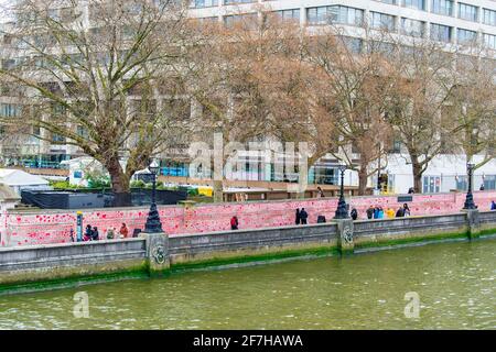 London, UK. 07th Apr, 2021. People walking past the National Covid Memorial Wall.The wall is adjacent to St Thomas' Hospital and is being hand-painted with 150000 hearts to honour UK Covid-19 victims, it stretches over 700 metres long. (Photo by Dave Rushen/SOPA Images/Sipa USA) Credit: Sipa USA/Alamy Live News Stock Photo