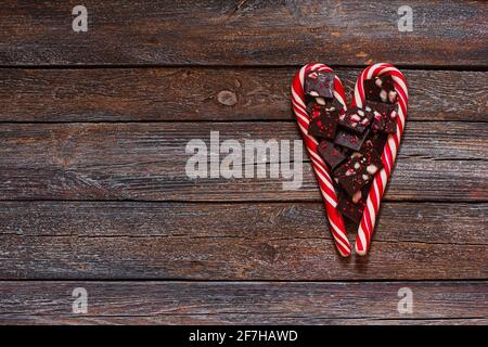 Red heart-shaped lollipop and chocolates of Valentines day on wood texture background. Valentines day background Stock Photo