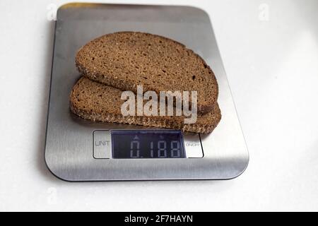 Two pieces of rye bread are weighed on a kitchen scale. Diet Stock Photo -  Alamy