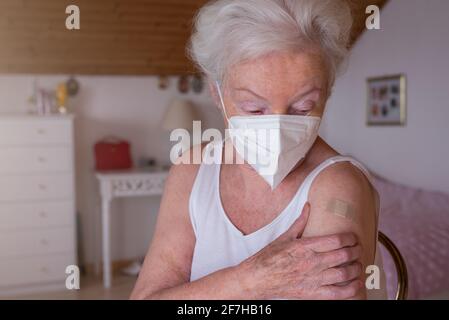 Senior woman feels pain in the arm after vaccination Stock Photo