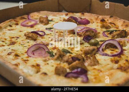 Pizza saver or ottoman, known also as pizza table, used in pizza deliveries to save the pizza being squished in a cardboard box. Tasty delicious pizza Stock Photo