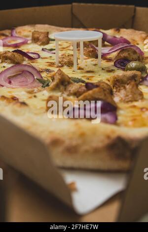 Pizza saver or ottoman, known also as pizza table, used in pizza deliveries to save the pizza being squished in a cardboard box. Tasty delicious pizza Stock Photo