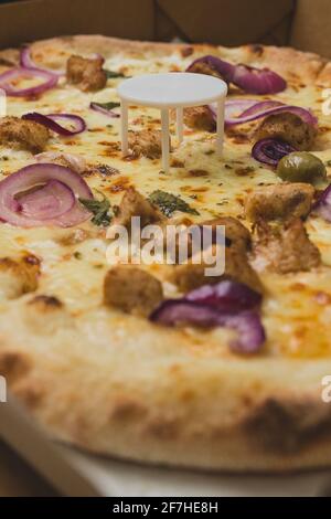 Pizza saver or ottoman, known also as pizza table, used in pizza deliveries to save the pizza being squished in a cardboard box. Tasty delicious pizza Stock Photo