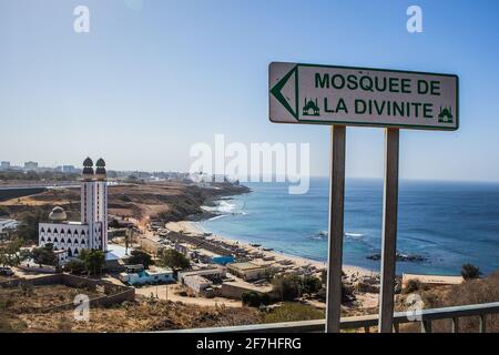 Mosque of divinity or mosquee de la divinite in Dakar, Senegal, behind a signboard leading towards the mosque on a sunny day. City of Dakar in the bac Stock Photo