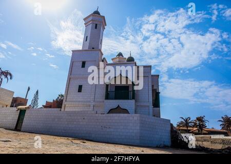 Grand Mosque de Warar, white and green islamic church on the edge of the beach in Tonghor, Dakar, on a sunny day with some clouds. Stock Photo