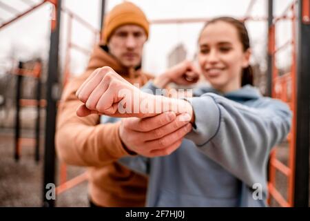 Close up young man and woman stretching they muscle before running on street sports ground. Staying fit and healthy concept. Stock Photo