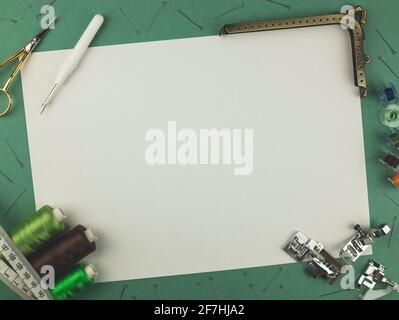 Sewing accessories on a mint-colored background with copy space. Scissors, sewing threads, pins, centimeter and other supplies. Top view Stock Photo