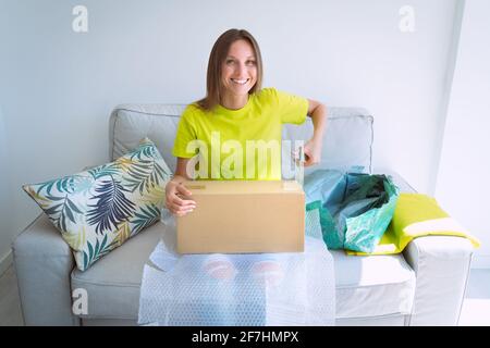 Woman opens cardboard box or parcel package from online store. Unboxing package Stock Photo