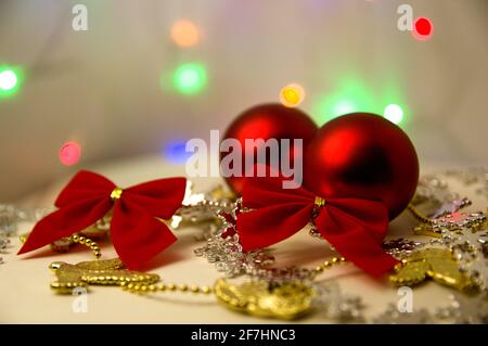 Image of some balls and decorations for the red Christmas tree, with out-of-focus lights in the background where there is copy space Stock Photo