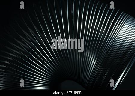Metal spring toy with black background. Stock Photo