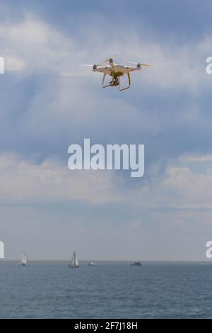 Drone in flight flying over the ocean Stock Photo