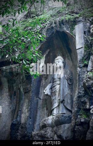 A carved Buddha statue on a stone wall in Lingyin Temple locates in Hangzhou, Zhejiang, China. Stock Photo