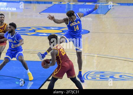 UCLA Bruins forward Kenneth Nwuba (14) attempts to block USC Trojans guard Ethan Anderson (20) from inbounding the ball during an NCAA basketball game Stock Photo