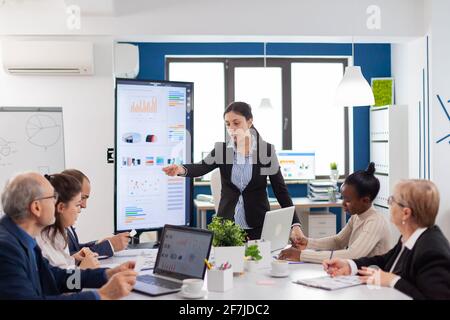 Angry company ceo having a dispute with multiethnic employees during briefing in meeting room. Businesswoman raging about multitasking difficult job, screaming in boardroom Stock Photo