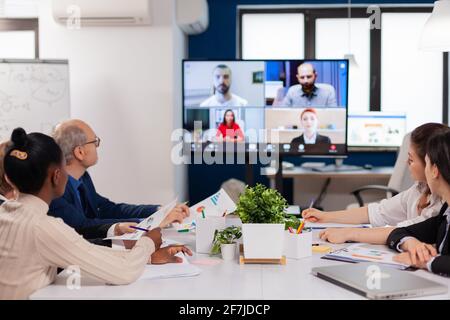 Headshot screen application view of remote multiracial employees talking on video call brainstorm together. Business people talking to webcam, do online conference participate internet brainstorming, distance office discussion. Stock Photo