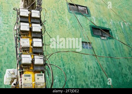 Many old dirty electric meters attached to a pole along the road, connecting electricity to residential household on Boracay Island, Philippines, Asia Stock Photo