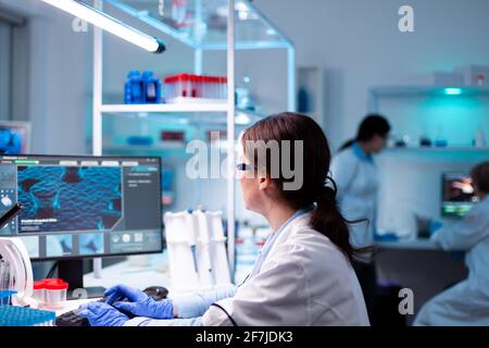 Specialist scientist pharmacology working on computer in hospital vaccine engineering. Chemistry research technology in science medicine lab developing and stying new type of vaccine. Stock Photo