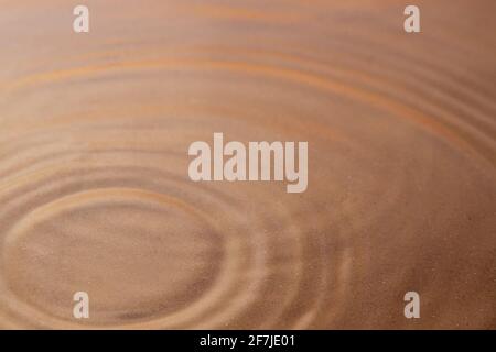 Circles on the water under which you can see sand-white. Background image. Close-up Stock Photo