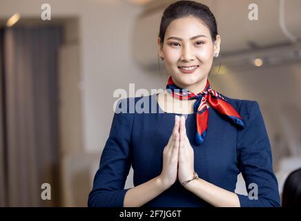 Cabin crew or Stewardess greeting passengers on airplane, Air hostess or stewardess service Stock Photo