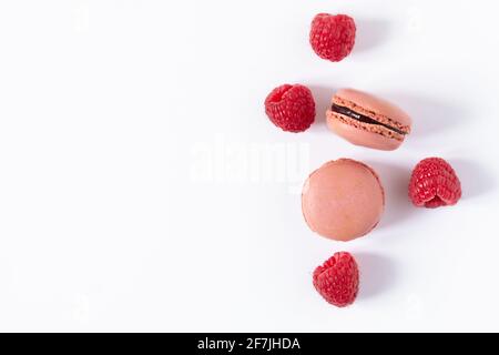 Raspberry macaroons dessert on white background top view. French meringue cookie macarons background. Stock Photo