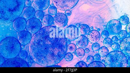 macro of oil drops and pigment on water surface with bright background Stock Photo