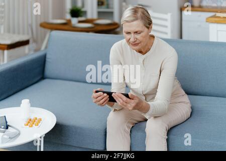 elderly woman looking at the screen of her smartphone . Stock Photo