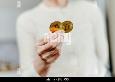 image of two bitcoins in the hands of a woman. Stock Photo