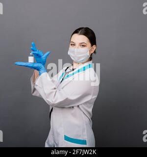 Beautiful female doctor in protective mask looking away and thinking about something. Stock Photo