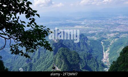 Green mounatins with river valley geomorgy in Zhangjiajie national forest park, with tree branch nearby. Stock Photo